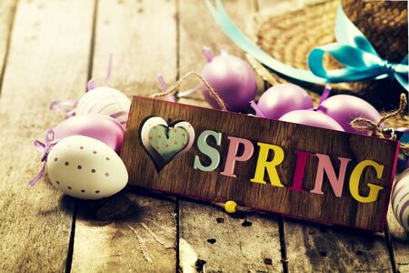 Easter Spring Concept. Eggs with Straw Hat on Wooden Background. Horizontal.