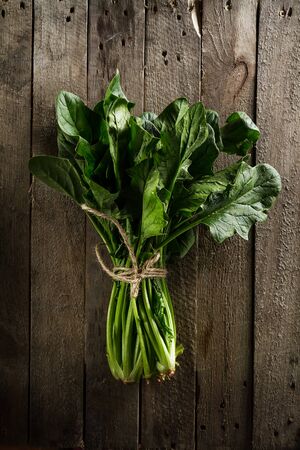 Fresh Colorful Vibrant Bundle of Spinach on Wooden Table. Summer, Spring, Healthy Life or Detox Concept.の写真素材