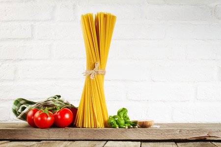 Tasty Fresh Colorful Italian Food Raw Spaghetti on Kitchen Table on Kitchen Background. Cooking or Healthy Food Concept. の写真素材