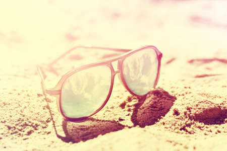 Summer or Vacation Concept. Beautiful Sunglasses on Sand. Beach. Lifestyle. Toning.の写真素材