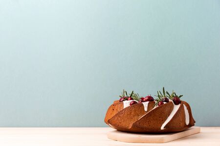 Shaped cake topped with icing and garnished with natural decor served on blue background fo Christmas.の写真素材