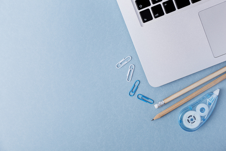 From above shot o blue surface with composed pencils and other stationery with laptop. の写真素材