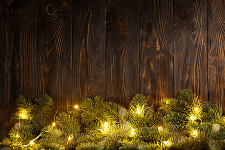 From above fir tree branches decorated for Christmas with lighting garland. の写真素材