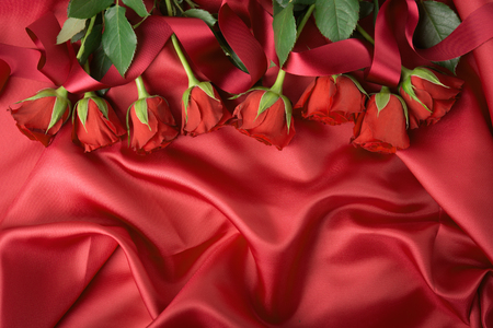 Top view of red colored blooming roses on textile background. の写真素材