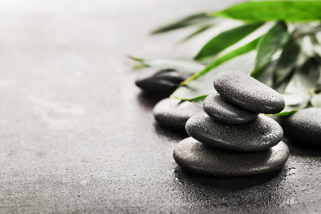 Stones for spa and green leaves on dark background.の写真素材