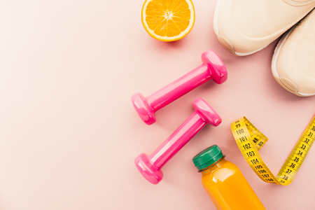 Top view of dumbbells with juice and sneakers on pink background. の写真素材