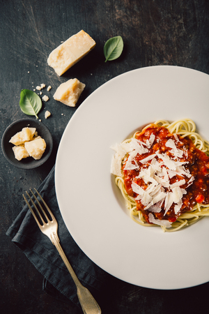 From above white restaurant plate filled with pasta with cheese and tomato sauce. の写真素材