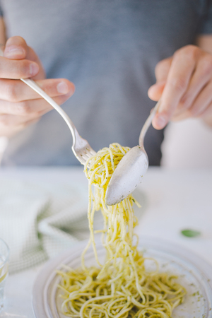 Young man eating tasty italian pasta. Healthy eating conceptの写真素材