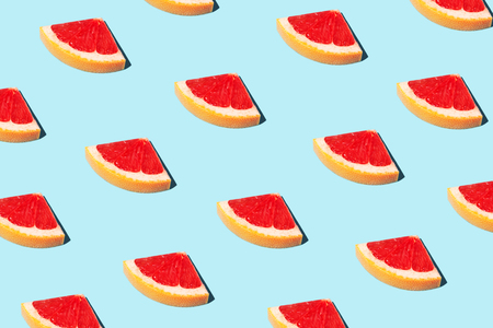 Beautiful food pattern, food fashion concept with half slices of grapefruit on blue background.  