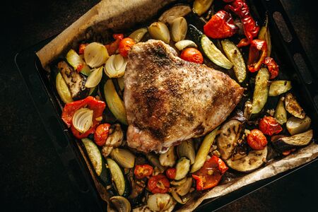 Tasty appetizing baked meat with vegetables on tray. View from above.の写真素材