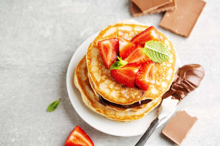 Tasty appetizing freshmade pancakes decorated with strawberry and chocolate paste served for breakfast. Closeupの写真素材