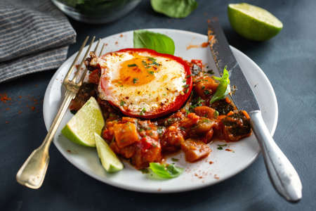 Fried egg with vegetables served on plate for breakfast. Closeup.の写真素材