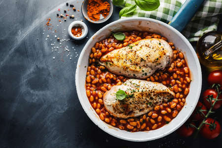 Chicken breast cooked or stuffed with beans in tomato sauce on pan.の写真素材
