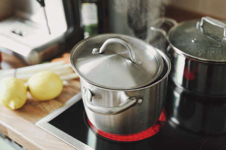 Steaming pot staying on the kitchen stove. Closeup.の写真素材