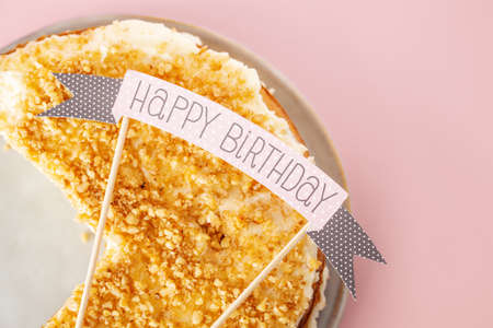 Birthday cut cake with weapon Happy Birthday served on pink background. Happy birthday concept.の写真素材
