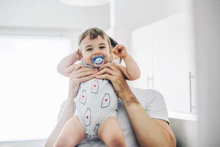Father playing with baby in the kitchen. Lifestyle. Family conceptの写真素材