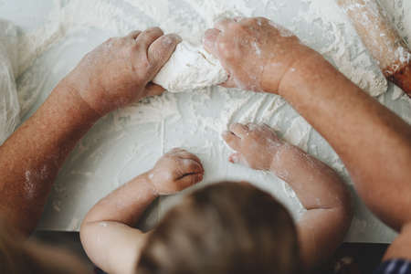 Grandmother and grandson cooking together homemade pastry dough. Learning process