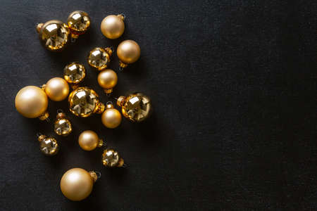 Christmas golden baubles on dark background. Flat Lay.の写真素材