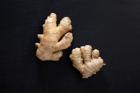 Whole ginger on dark background. Closeup