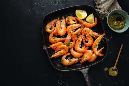 Tasty shrimps with spices and sauce on pan on dark background. Top View.の写真素材