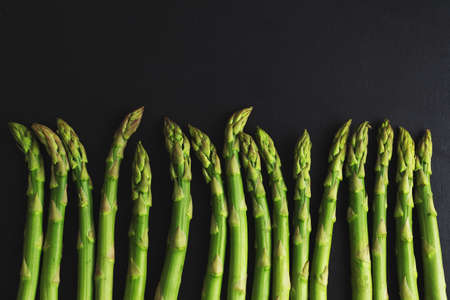 Green asparagus on dark background ready for cooking. View from above.の写真素材