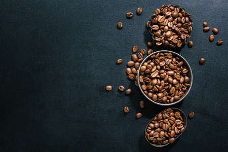 Coffee beans in small bowls on dark background. Top view. Coffee concept.の写真素材