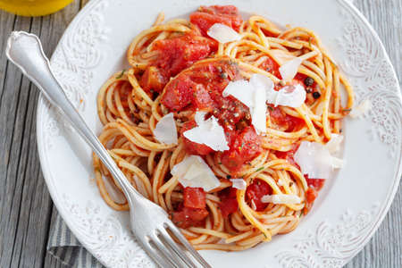 Tasty classic italian pasta with tomato sauce and cheese on plate. Closeup.の写真素材