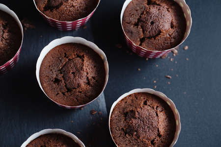 Tasty appetizing chocolate muffins in cups on dark background.の写真素材