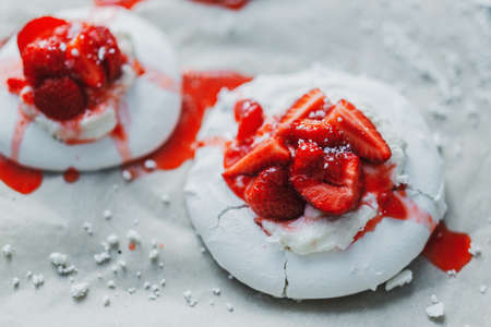 Closeup of homemade white merengue baiser with strawberry and jam.の写真素材