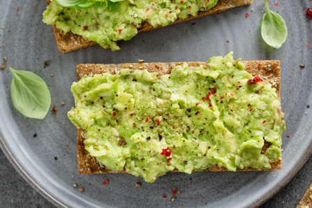 Tasty appetizing crispbread with mashed avocado served on plate.の写真素材