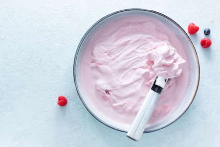 Homemade fruity berry ice cream with ice cream spoon in bowl.