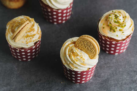 Vanilla cupcakes with cream and caramel on gray table background.の写真素材