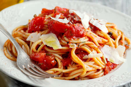 Tasty classic italian pasta with tomato sauce and cheese on plate. Closeup.の写真素材
