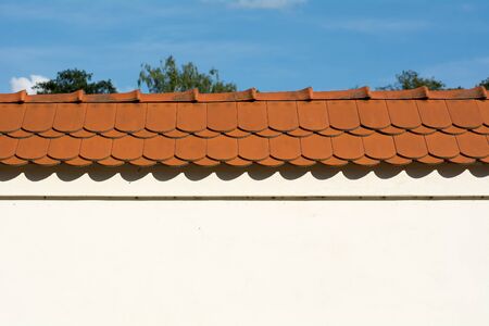 Nice clean wall with light facade and red roof.の写真素材