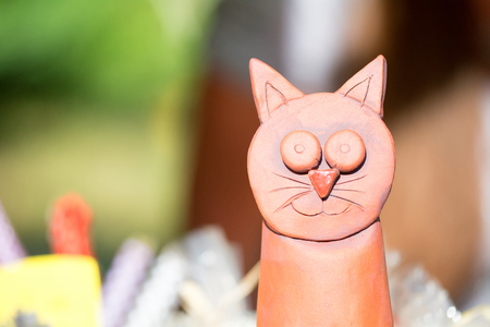 Detail of red ceramic cat with blurred background.の写真素材