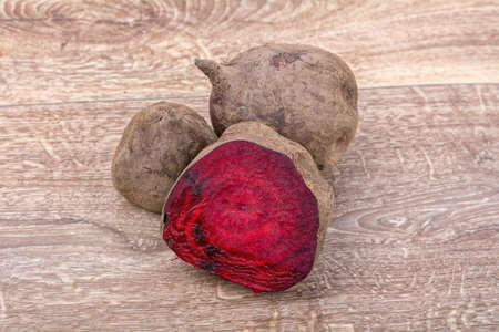 The red beets on a brown wooden background