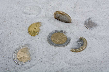 Coins in a grey sand backgroundの写真素材