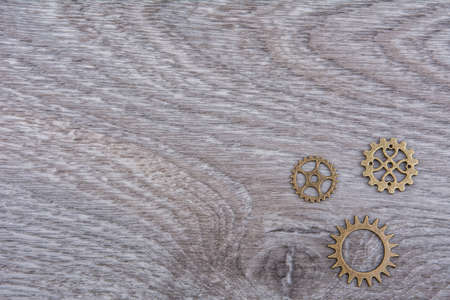 Small gears on a grey wooden background