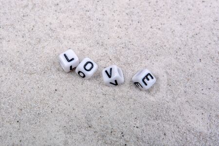 White boxes with love inscription on a grey sandの写真素材
