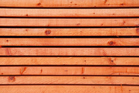 Closeup pattern of cutting red wood stack for backgroundの写真素材