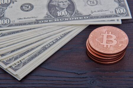 Dollar banknotes and Bitcoins on a wooden tableの写真素材