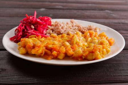 Stewed carrots with chickpeas and buckwheat on a wooden tableの写真素材