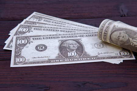Dollar banknotes on a dark wooden table