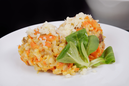 Risotto with carrot and cheese on black backgroundの写真素材