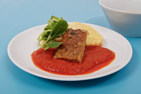 Tempeh with tomato sauce and dumplings on a blue backgroundの写真素材