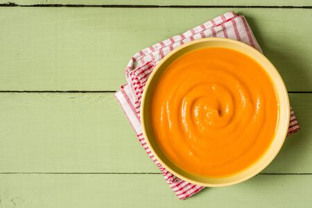 Pumpkin soup on green rustic wooden background. Top view.の写真素材