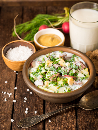 Okroshka. Traditional Russian summer cold yogurt soup in bowl on wooden background. Selective focus.の写真素材