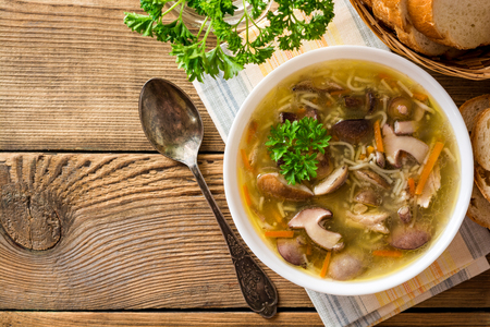 Chicken soup with mushrooms and noodles on rustic wooden table. Top view.の写真素材