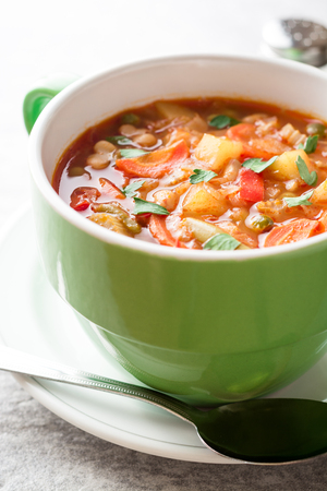 Italian minestrone soup in bowl on gray stone background. Selective focus.の写真素材