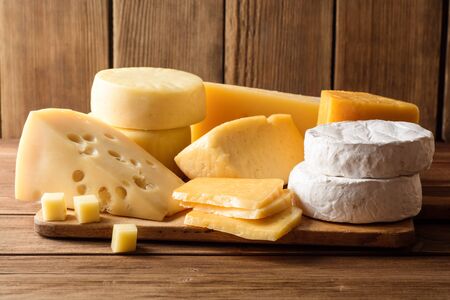 Various types of cheese on dark rustic wooden background. Selective focus.の写真素材